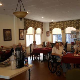 A group of elderly residents enjoying a meal in a cozy dining room.