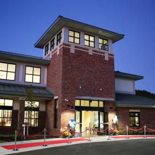 Brick building with illuminated windows in the evening.