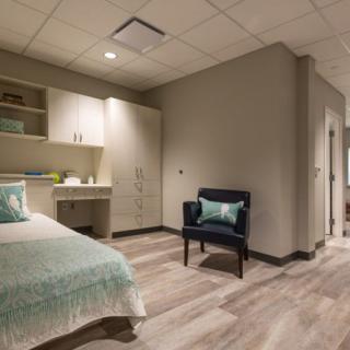 A modern and cozy bedroom with stylish decor and wood flooring.
