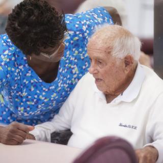 A caregiver provides support and companionship to a senior citizen.