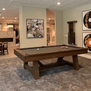 A modern recreation room with a pool table and stylish artwork.