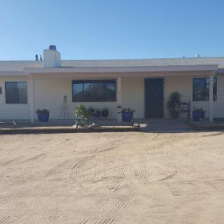 A front view of a single-story house with a clear blue sky.