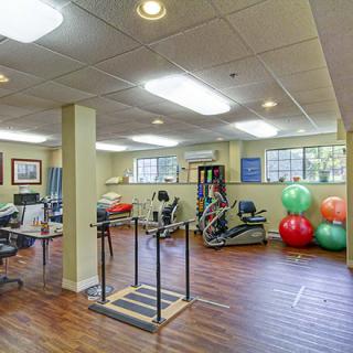 A fitness and rehabilitation center equipped with various exercise machines and therapy balls.