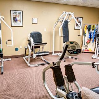 A small gym room with various exercise machines and fitness equipment.