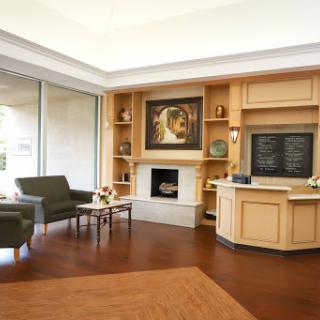 A cozy and modern living room featuring comfortable seating, a fireplace, and decorative shelving.