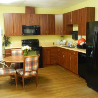 A cozy kitchen with wooden cabinets, a dining table, and modern appliances.