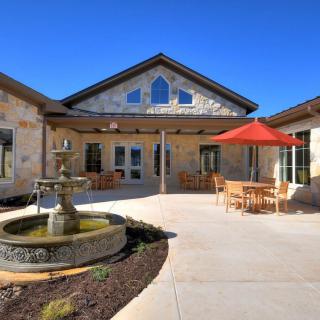 A stone building with a courtyard featuring a fountain and patio furniture.
