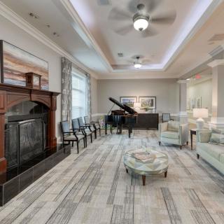 A modern living room featuring a grand piano and a cozy fireplace.