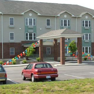 A suburban apartment complex with a parking lot and cars.