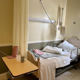 A hospital room with a bed and medical equipment.