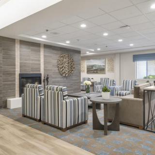 A modern living room with striped chairs and a fireplace, featuring elegant decor.