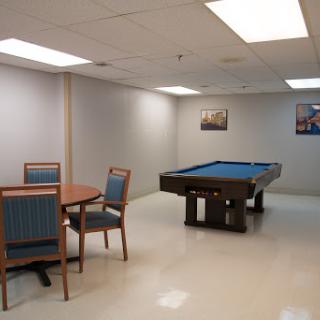 A spacious game room featuring a pool table and a dining area.
