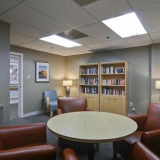 A cozy lounge area with comfortable seating and bookshelves filled with books.