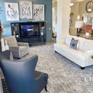 A cozy and modern living room featuring a stylish sofa, armchairs, and decorative elements.