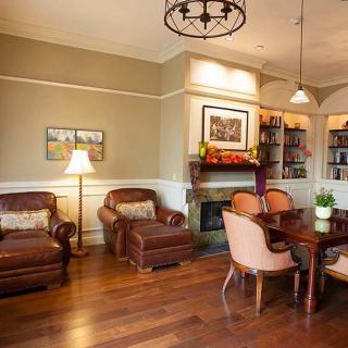 A cozy living room featuring leather armchairs, a wooden table, and a fireplace.