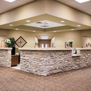 A modern reception area featuring a stone-clad front desk and warm interior lighting.
