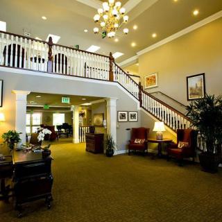 A spacious hotel lobby with elegant furniture and a grand staircase.