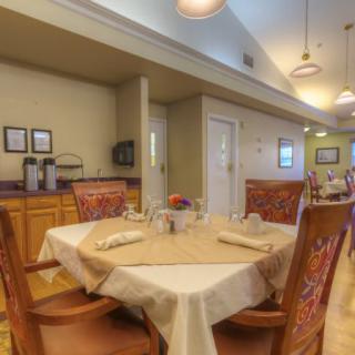 A cozy dining area with elegantly set tables and comfortable chairs.