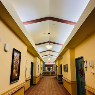 A well-lit interior hallway featuring decorative elements and artwork along the walls.