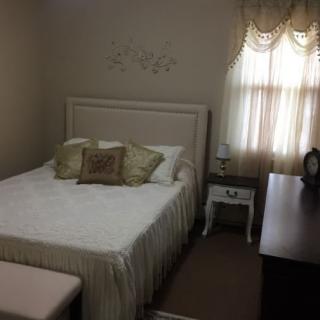 A cozy bedroom with a neatly made bed and soft lighting.