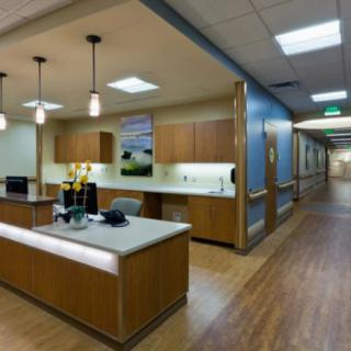 A modern hospital reception area with a well-lit corridor and wooden flooring.