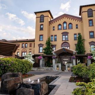 A beautiful hotel building with charming architecture, surrounded by a landscaped garden and pathway.
