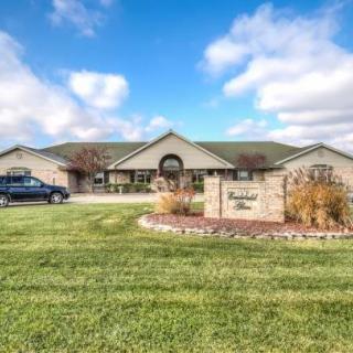 A suburban house with a well-maintained lawn under a partly cloudy sky.