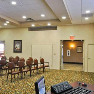 An empty conference room with arranged chairs and a carpeted floor.