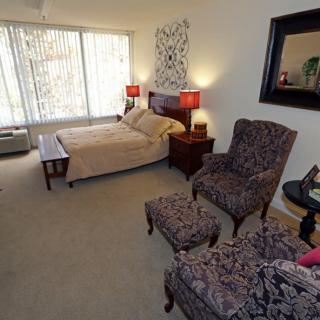 A cozy bedroom with stylish furniture and warm lighting.