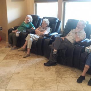 A group of seniors relaxing on comfortable chairs indoors.