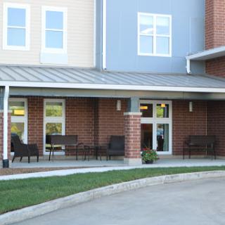 A modern residential building featuring an inviting patio area with seating.