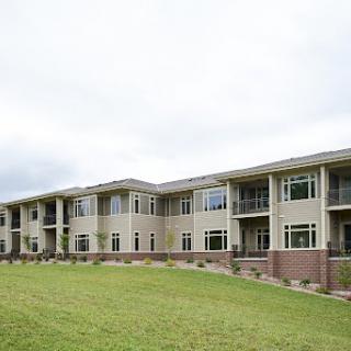 A view of a modern apartment building set against a cloudy sky.
