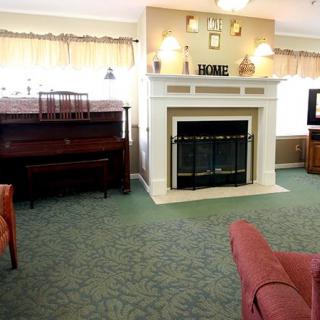 A cozy living room featuring a fireplace and a piano.