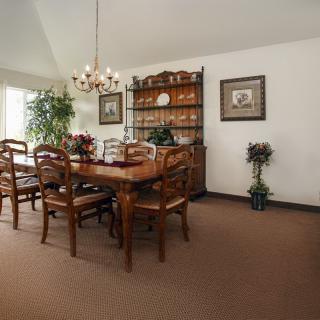 A classic dining room with a wooden table set and chandelier.