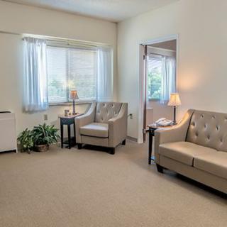 A cozy living room with comfortable seating and natural light streaming through the window.
