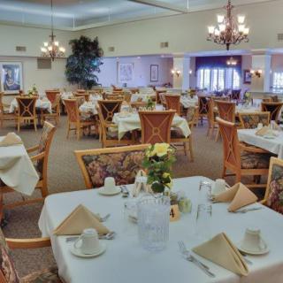 An elegantly decorated dining room with neatly arranged tables and chairs, ready for guests.
