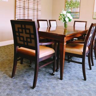 A beautifully set dining room with a wooden table and chairs.
