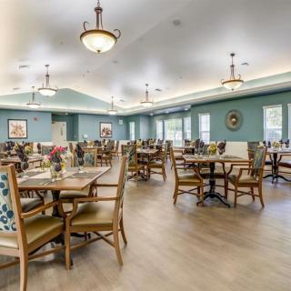 A spacious and elegantly decorated dining room with multiple tables and chairs arranged neatly.