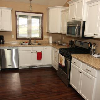 A modern kitchen with white cabinets and stainless steel appliances.