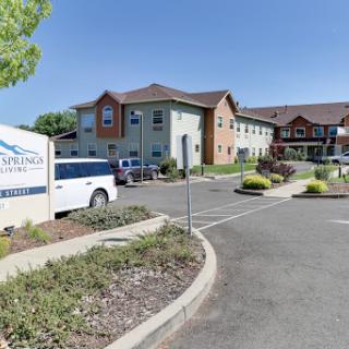 A view of a hotel showing its entrance and parking area.