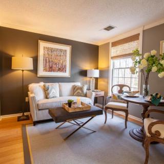 A cozy living room with elegant decor, featuring a sofa, coffee table, and artwork.