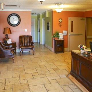 A cozy reception area with comfortable seating and a classic wooden desk.