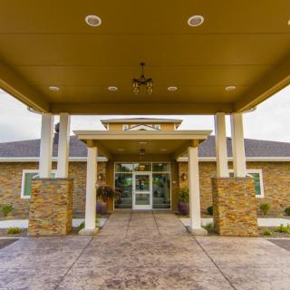 Front entrance of a modern building with stone columns and an awning.