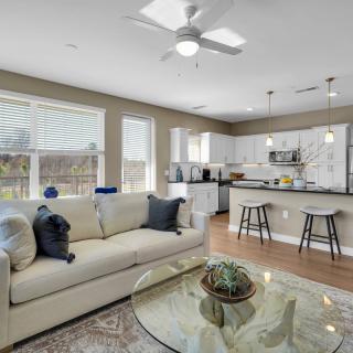 A modern open-concept living room and kitchen with ample natural light.