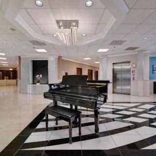 A luxurious lobby featuring a grand piano and elegant chandelier.