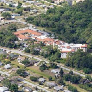 An aerial view of a residential area with buildings surrounded by trees.