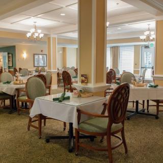 An elegant dining area with neatly arranged tables and chairs, featuring soft lighting and tasteful decor.
