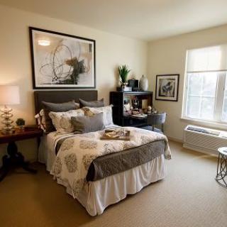 A cozy and well-decorated bedroom with a bed, nightstand, and wall art.