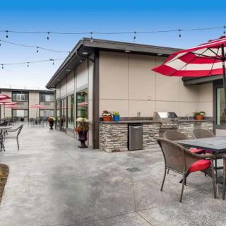 Modern outdoor patio area with seating and red umbrellas.