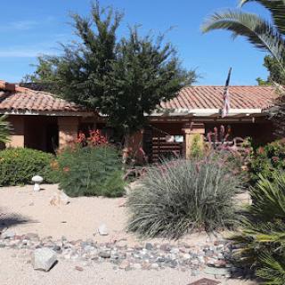A scenic view of a southwestern-style house surrounded by desert flora.